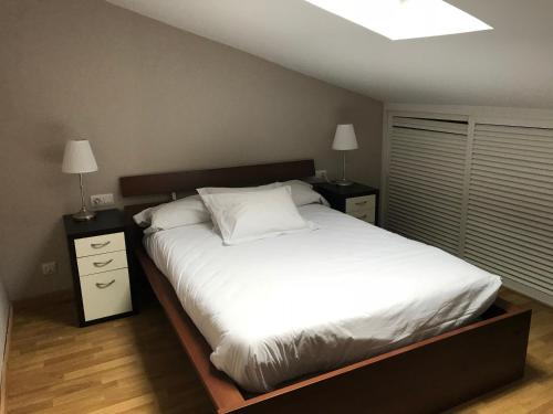 バレンシアにあるAtico En El Centroのベッドルーム1室(白い大型ベッド1台、ナイトスタンド2台付)