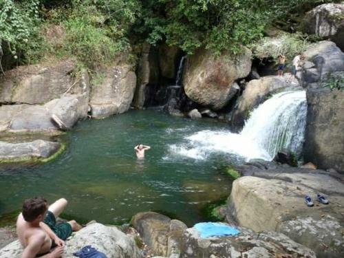 two men sitting in a pool of water near a waterfall at Hotel Anachoreo in Santa Fe