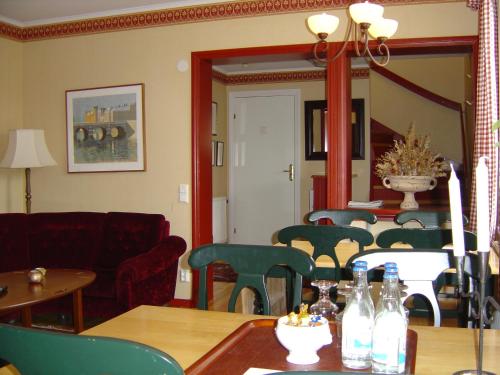 a living room with a table and chairs and a mirror at Hotell Mellanfjärden in Jättendal