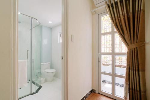 La salle de bains est pourvue d'une douche, de toilettes et d'une fenêtre. dans l'établissement Chez Mimosa Boutique - New address 135 Tran Hung Dao, à Hô-Chi-Minh-Ville