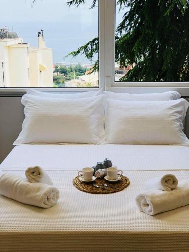 a bed with towels and two cups and a tray with two towels at K&B Luxury Studios in Kavála