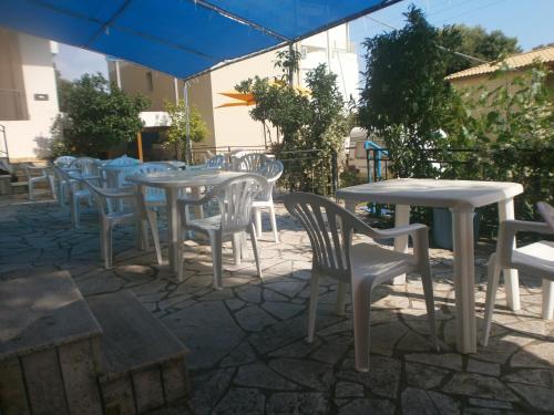 a patio area with chairs, tables and umbrellas at Mehilli Hotel in Dhërmi