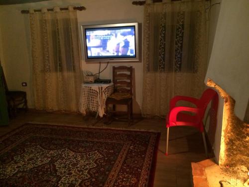 a living room with a television and a red chair at Bujtina Kometa in Theth