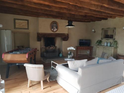 un salon avec un canapé et une cheminée dans l'établissement La clef des champs, à Meillac