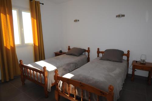 Farinoleにあるlocation farinole proche saint-florentのベッドルーム1室(隣り合わせのベッド2台付)