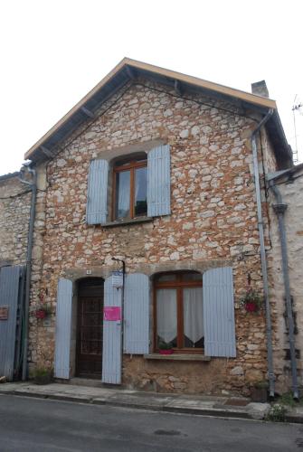 a brick building with windows and shutters on it at Les Fleurs in Monpazier