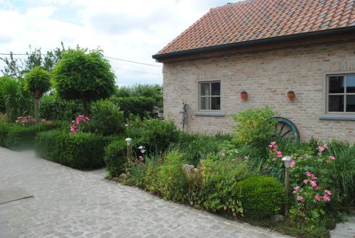 un jardin avec des fleurs en face d'une maison dans l'établissement Vakantiewoning 't Blooteland, à Dixmude