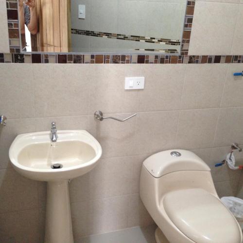a bathroom with a toilet and a sink at Hotel Almond Beach in Tonsupa