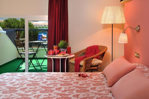 a bedroom with a bed and a table and a balcony at Hotel Roma in Gatteo a Mare