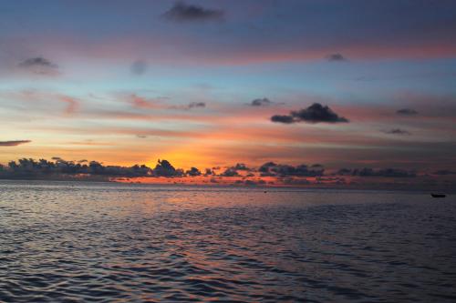 a sunset over a body of water at Evila Inn - Thoddoo in Thoddoo