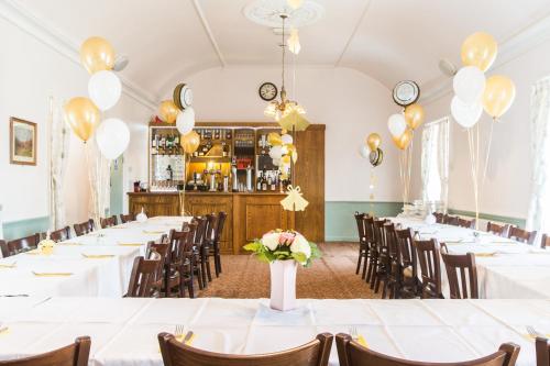 a row of tables in a banquet hall with balloons at The Swan in Thornbury