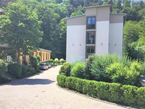 a house with a driveway in front of a building at Hotel Scheid in Schriesheim