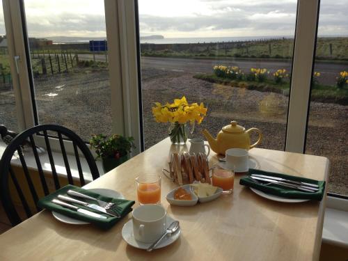 a table with a vase of flowers on top of it at Creag Na Mara B&B in Thurso