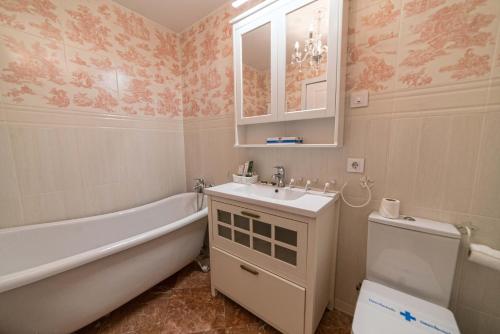 a bathroom with a tub and a sink and a toilet at Rey Don Pedro Luxury Home in Seville