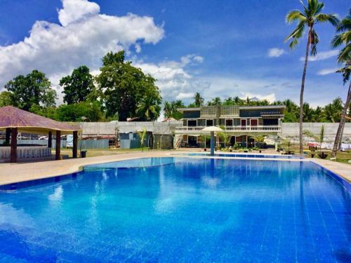 duży niebieski basen z budynkiem w tle w obiekcie Lagoon beach resort w mieście Gitagun