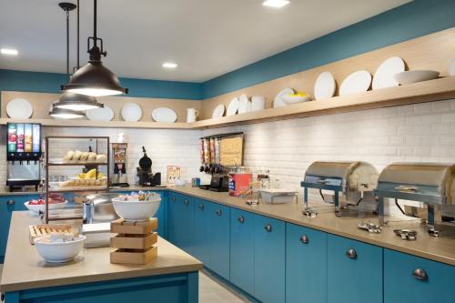 a kitchen with blue cabinets and white plates on the wall at Country Inn & Suites by Radisson, Lawrence, KS in Lawrence