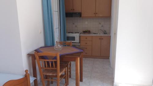 una piccola cucina con tavolo e sedie in legno di North Paradise a Athéras