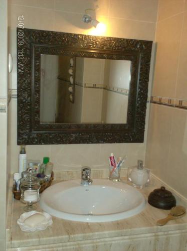 a bathroom with a sink with a mirror and a counter at Cantinho do Céu in Vila Real de Santo António
