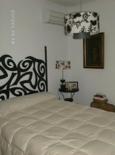 a bedroom with a bed with a black and white headboard at Cantinho do Céu in Vila Real de Santo António