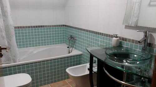 a bathroom with a tub and a sink and a toilet at Balcón de las Fuentes in Navarrés