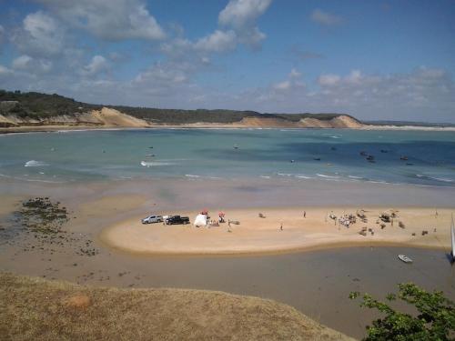 a group of people on a beach in the water at Casinhas Vila Bonita Hobbit in Baía Formosa