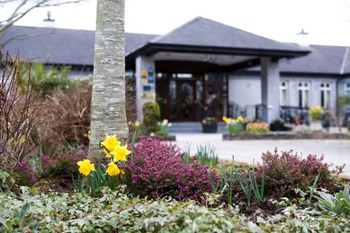 a garden with flowers in front of a building at Fitzgeralds Woodlands House Hotel in Adare