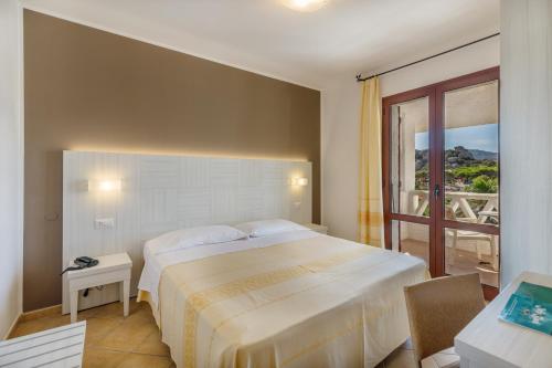 a bedroom with a large bed and a balcony at Hotel Mon Repos in Baja Sardinia