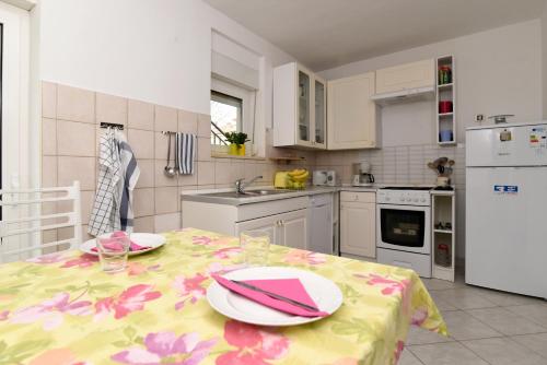 a kitchen with a table with plates and napkins on it at Apartman Blazek Kastav in Kastav