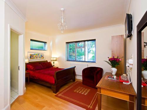 a living room with a red couch and a table at Godalming Hotel Guest House in Godalming