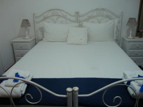 a bedroom with a white bed with white pillows at B&B Il Villino in Torre dell'Orso