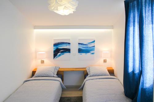 duas camas num quarto com cortinas azuis em Holiday Home Liberta em Krnica