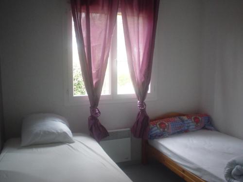 une chambre avec deux lits jumeaux et une fenêtre dans l'établissement comme chez vous, à Taussat-les-Bains