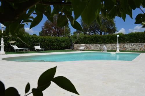 uma piscina com duas cadeiras num quintal em Masseria Paglieroni em Martina Franca