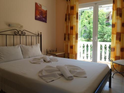 a bedroom with a bed with towels on it at Turtle Beach Apartment in Marathias