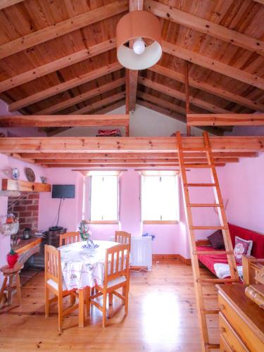 a dining room with a table and a ladder at Casa Azul in Nazaré