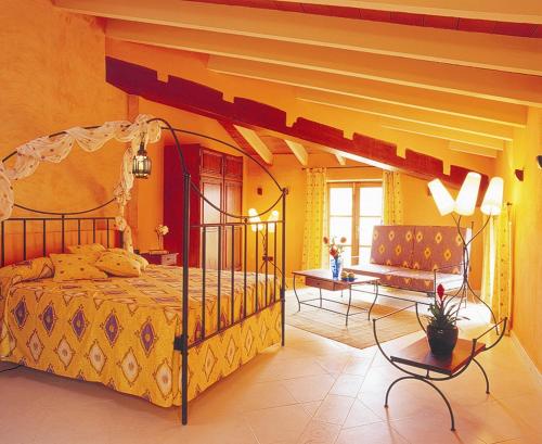 a bedroom with a canopy bed and a table at Palacio Sant Salvador in Artá