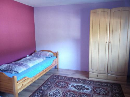 a bedroom with a bed and a cabinet and a rug at Ferienwohnung Gönnern - Marburg Biedenkopf mit 5 Zimmer - 2 Badezimmer in Gönnern