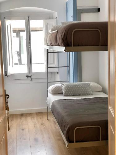 a bedroom with two bunk beds and a window at Vilamarlux II in Vilassar de Mar