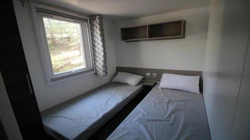 une chambre avec deux lits et une fenêtre dans l'établissement Mobile Home - Camping, aux Mathes