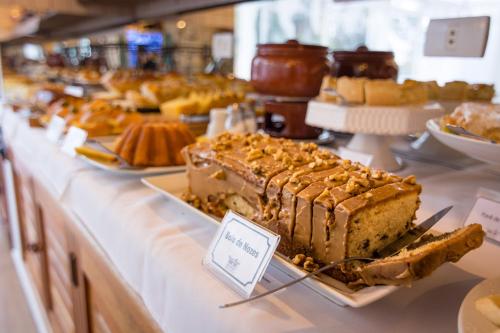 a buffet filled with different types of cakes and desserts at Pousada Piano Piano in Campos do Jordão