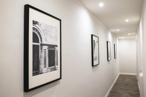 a row of framed photographs on a wall in a hallway at The Gallery 42 Guest House in Florence