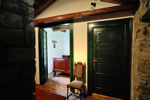 a hallway with a door and a chair in a room at Traditional Istrian Stone House in Šmarje