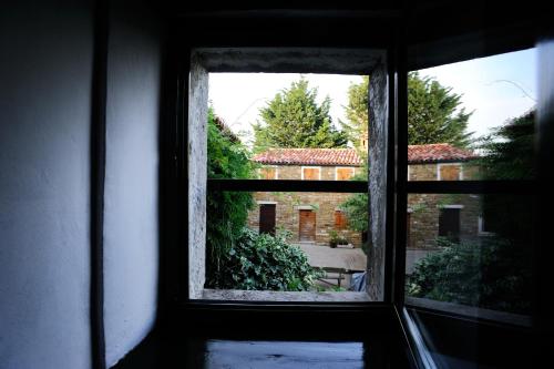an open window with a view of a house at Traditional Istrian Stone House in Šmarje