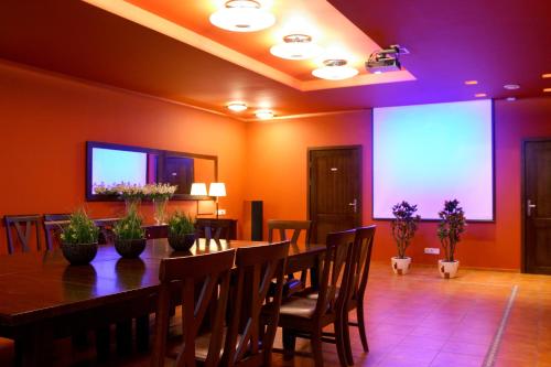 a dining room with a table and some plants at Hotel Sinchronas in Telšiai