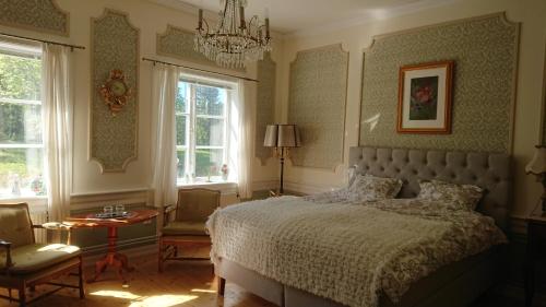 - une chambre avec un lit et un lustre dans l'établissement Salsåker Herrgård, à Salsåker