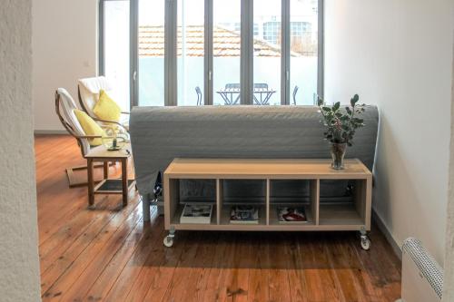 Sala de estar con cama, mesa y silla en Bonjardim Flats - T2 com Varanda, en Oporto