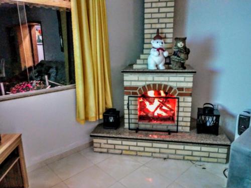 a brick fireplace with a cat sitting on top of it at Casa Amarela da Uruçu in Aracê