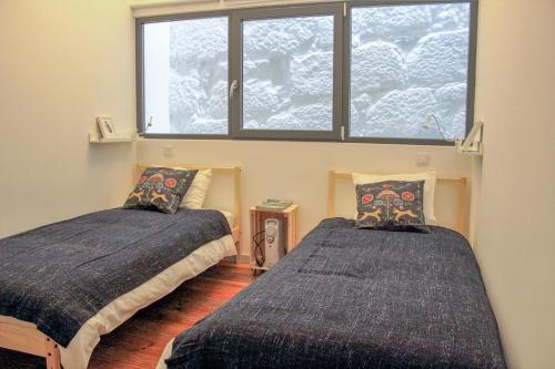 - une chambre avec deux lits en face d'une fenêtre dans l'établissement Bonjardim Flats - T1 + 1 com terraço, à Porto