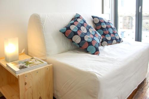 ポルトにあるBonjardim Flats - T1 com varandaの白いソファ(枕付)、テーブル(キャンドル付)