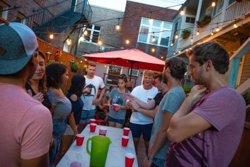 
a large group of people standing around a table at Auberge NOLA Hostel in New Orleans
